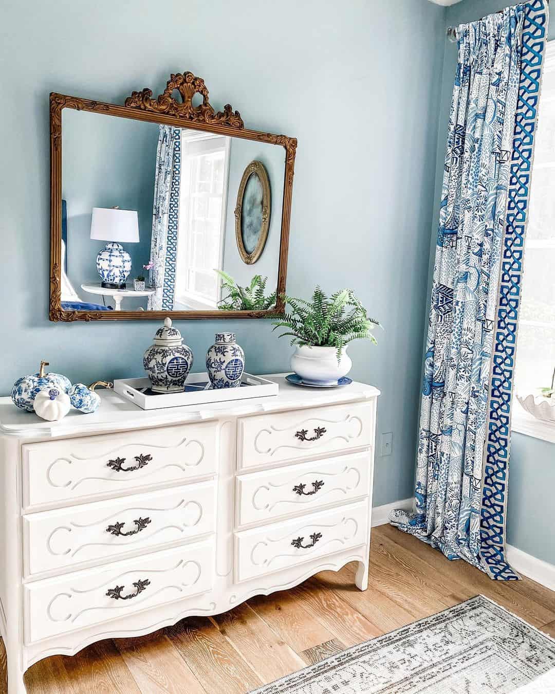 Ornate Mirror Reflects Blue and White Curtains