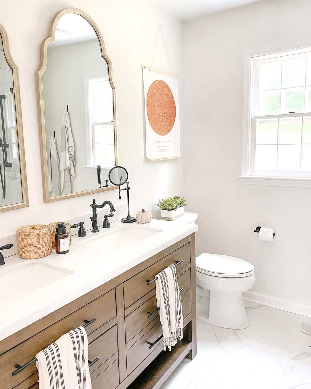 Arched Mirrors and Neutral Towels Complement a White Countertop