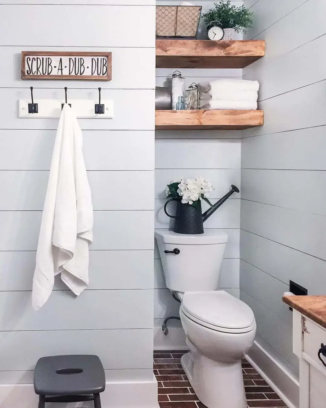Watering Can Holds Flowers Above the Toilet Tank
