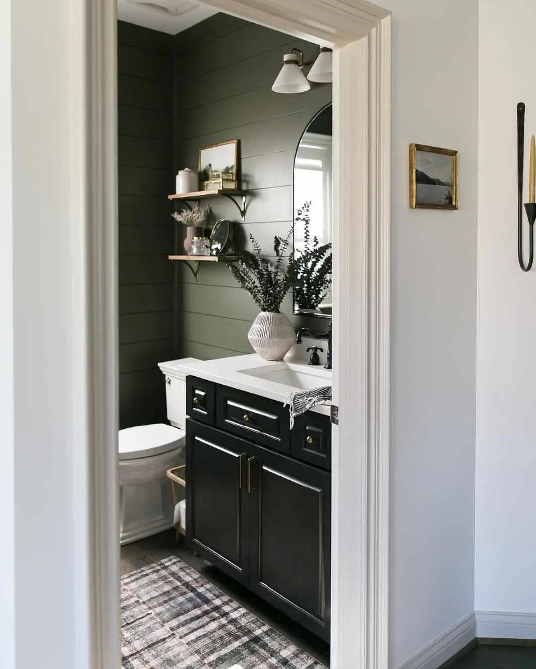 Small framed landscape art above toilet tank