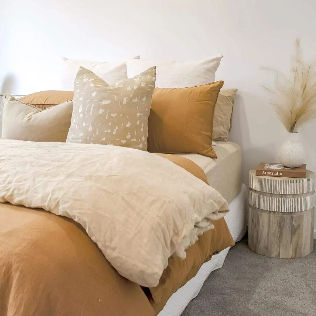 Layered Neutral Pillows Create a Cozy Bedside Vignette