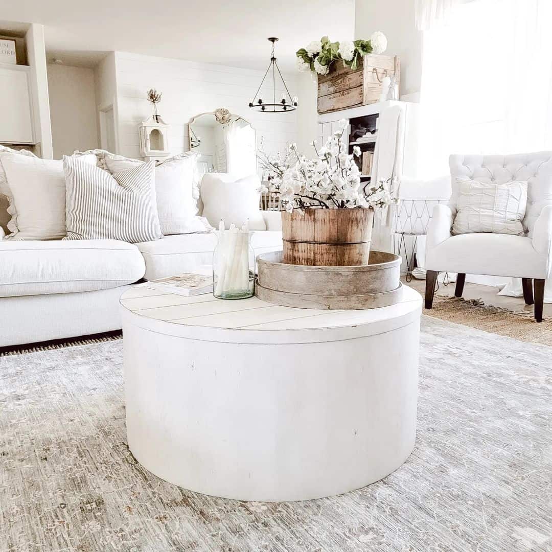 Round White Coffee Table With Stacked Wooden Treenware Decor