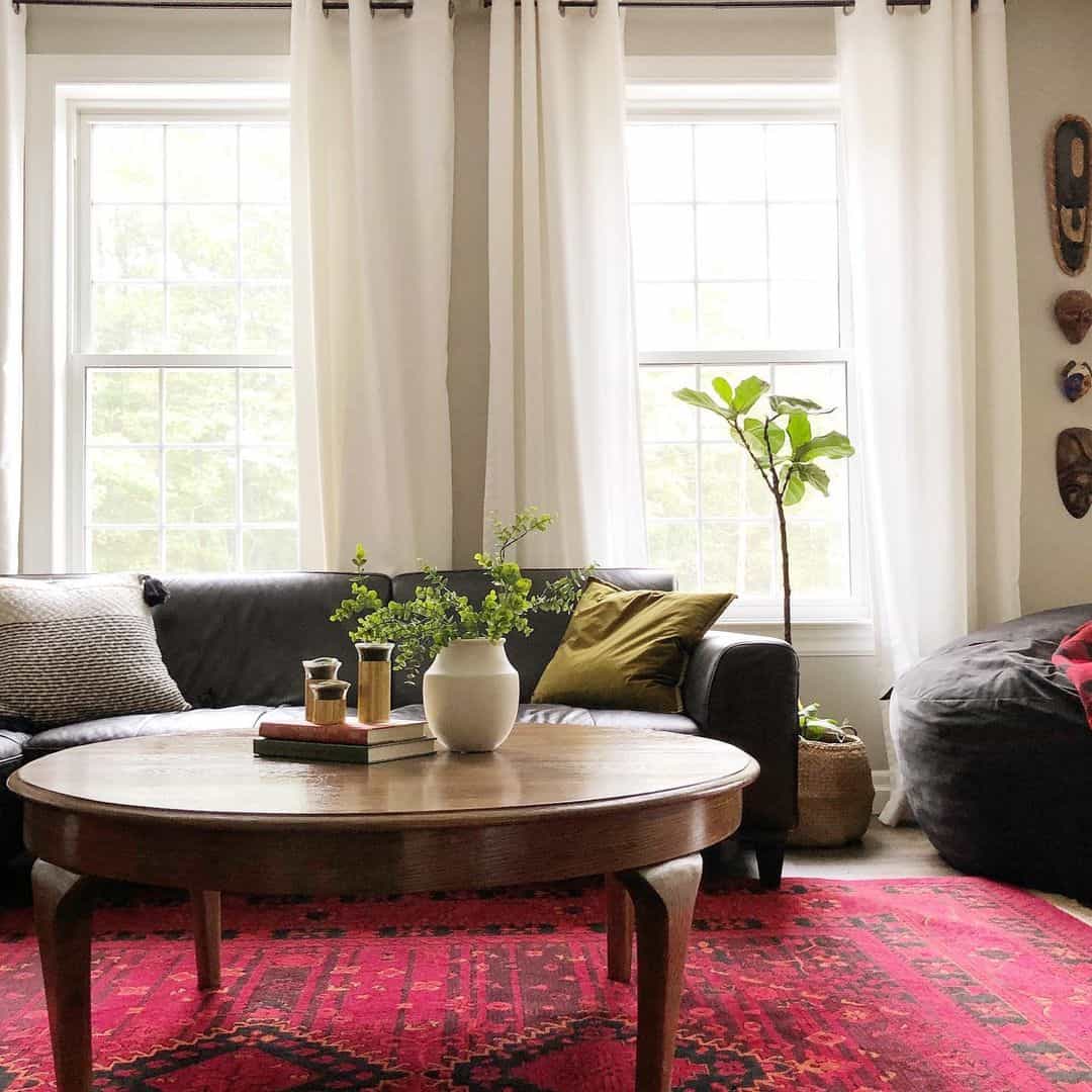 Round coffee table with stacked books and brass cylinders