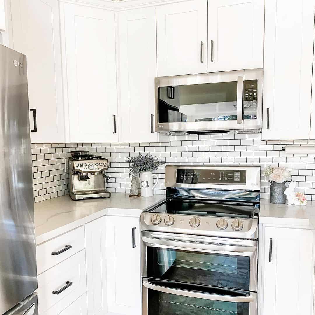 White Farmhouse Sink Holds A Small Bunch Of Pink Flowers