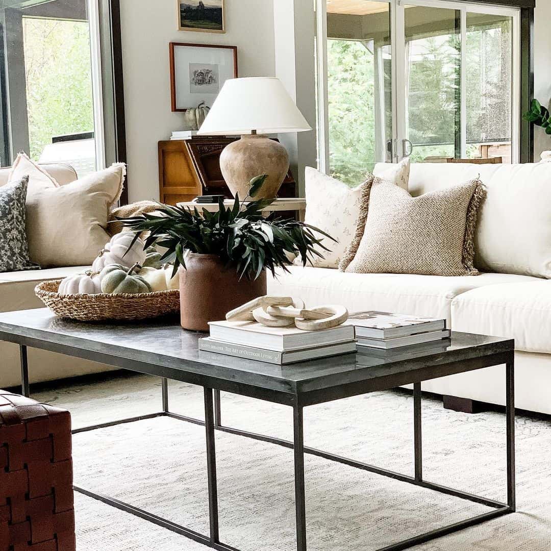 Dark Metal Coffee Table With Layered Books and Sculptural Decor