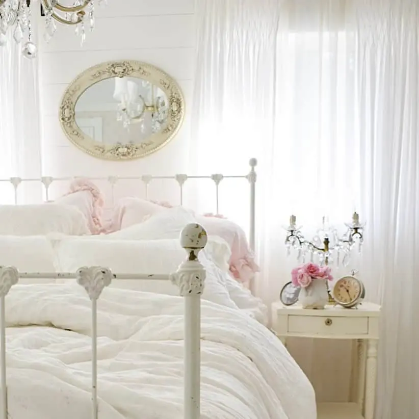 Ornate Oval Mirror Adds Vintage Flair Above a White Bed