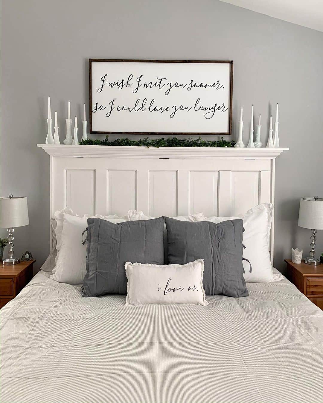 White Spindle Vases Hold Taper Candles Above Headboard