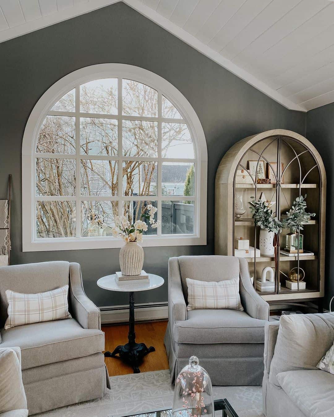 Arched Cabinet Displays Curated Decor at Varied Heights