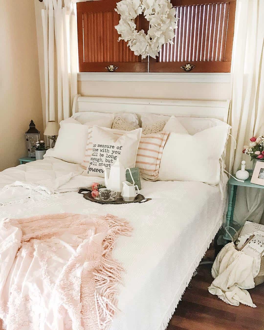 White Floral Wreath Frames Shutters Above Bed