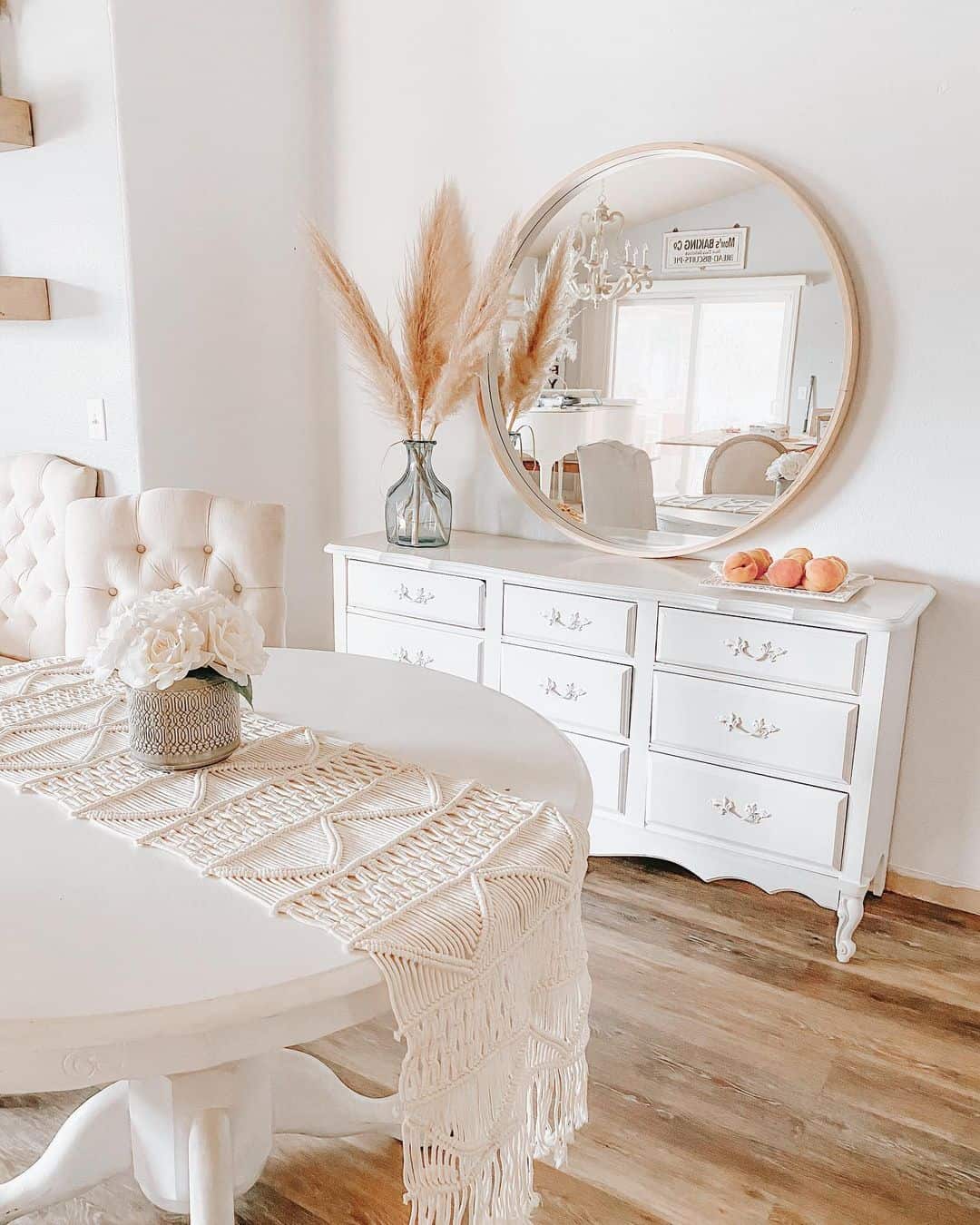 Round Mirror with Natural Wood Frame Above White Dresser