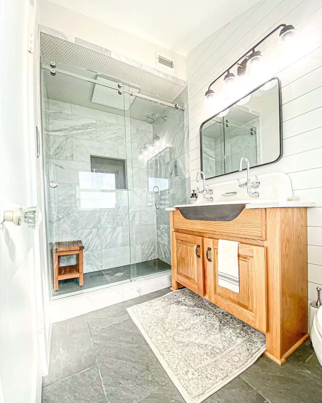 Wooden Vanity with Farmhouse Sink Grounds the Space in Rustic Charm