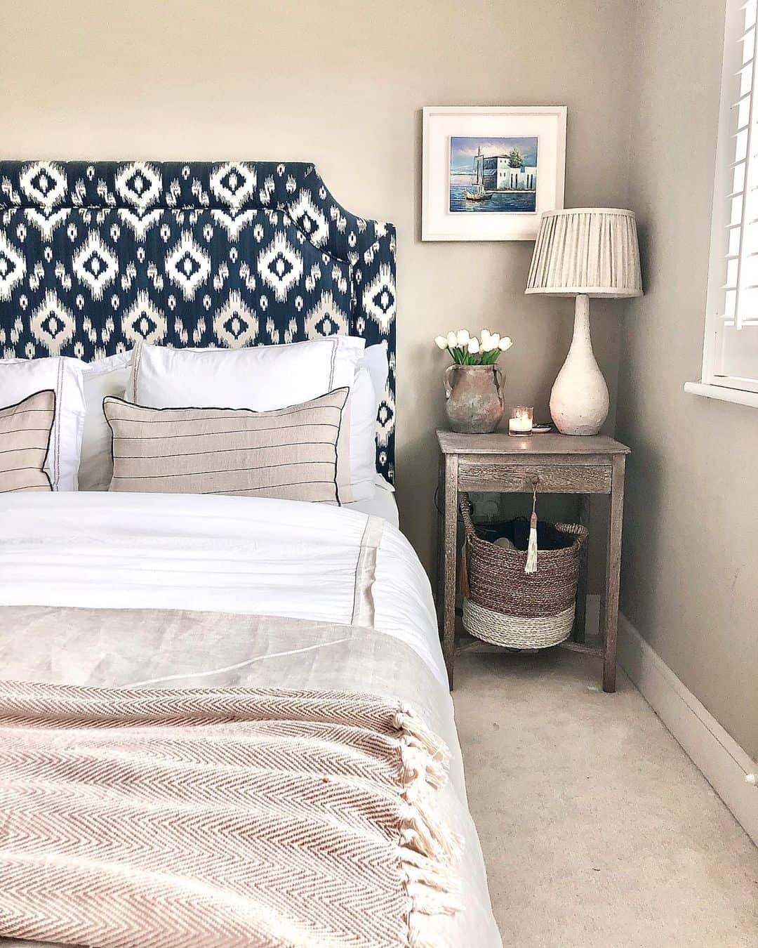 Bold Ikat Upholstered Headboard Anchors the Bed