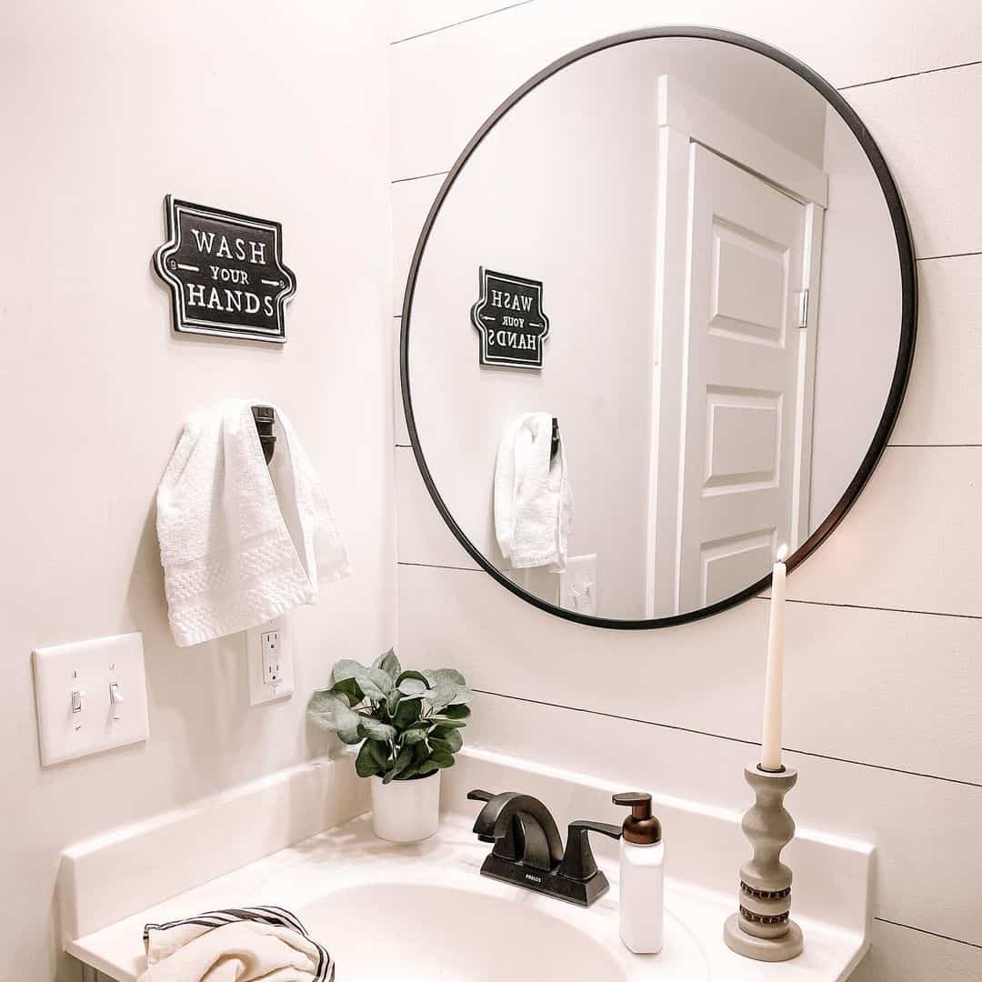 Round Black Mirror Frames a White Vanity with Farmhouse Accents