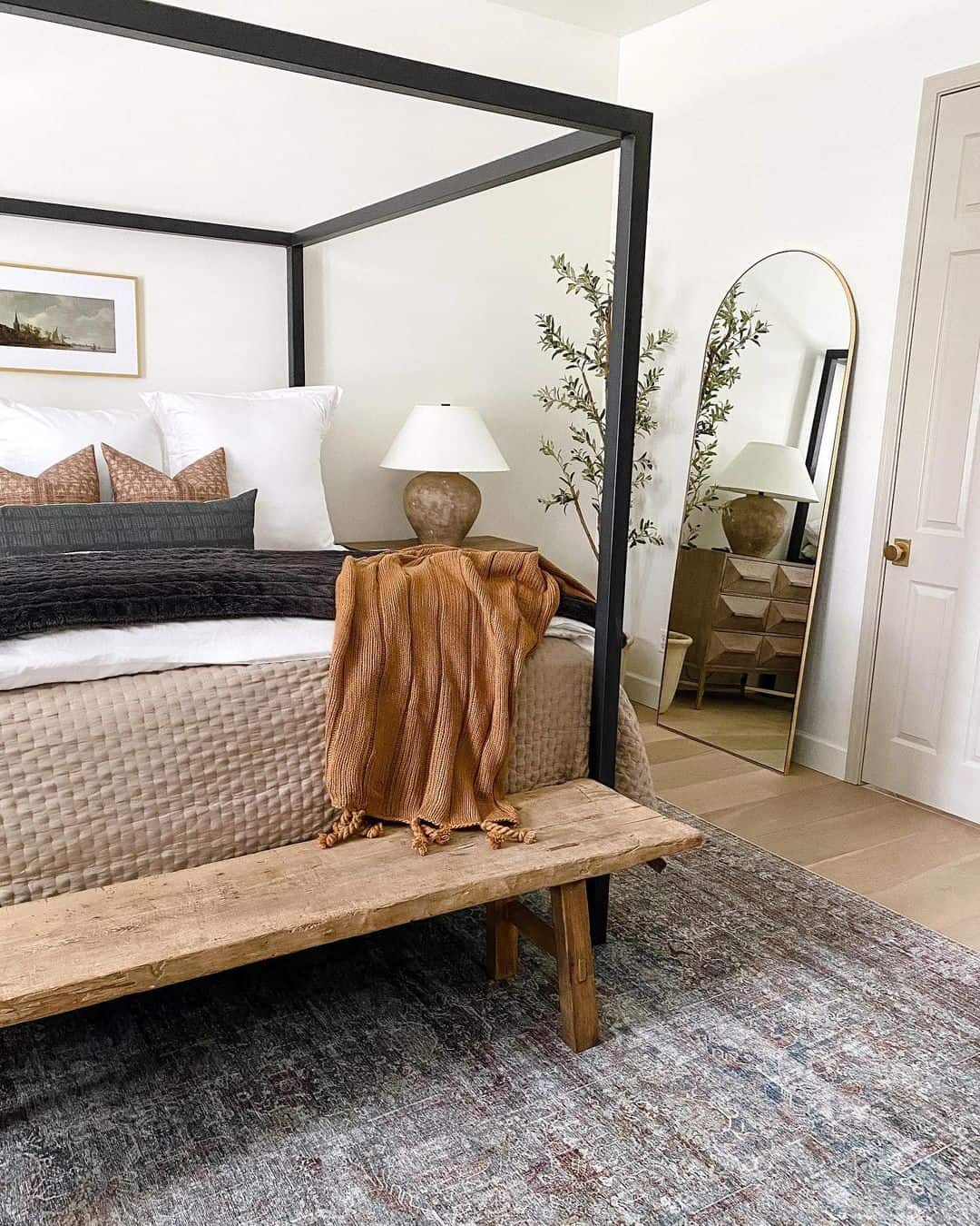 Tall Arched Mirror Frames a Dresser and Adds Warmth