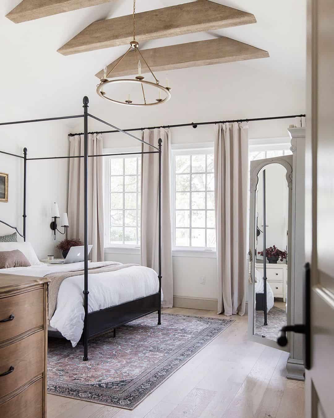 Tall Arched Mirror Reflects Bedroom Light and Layers
