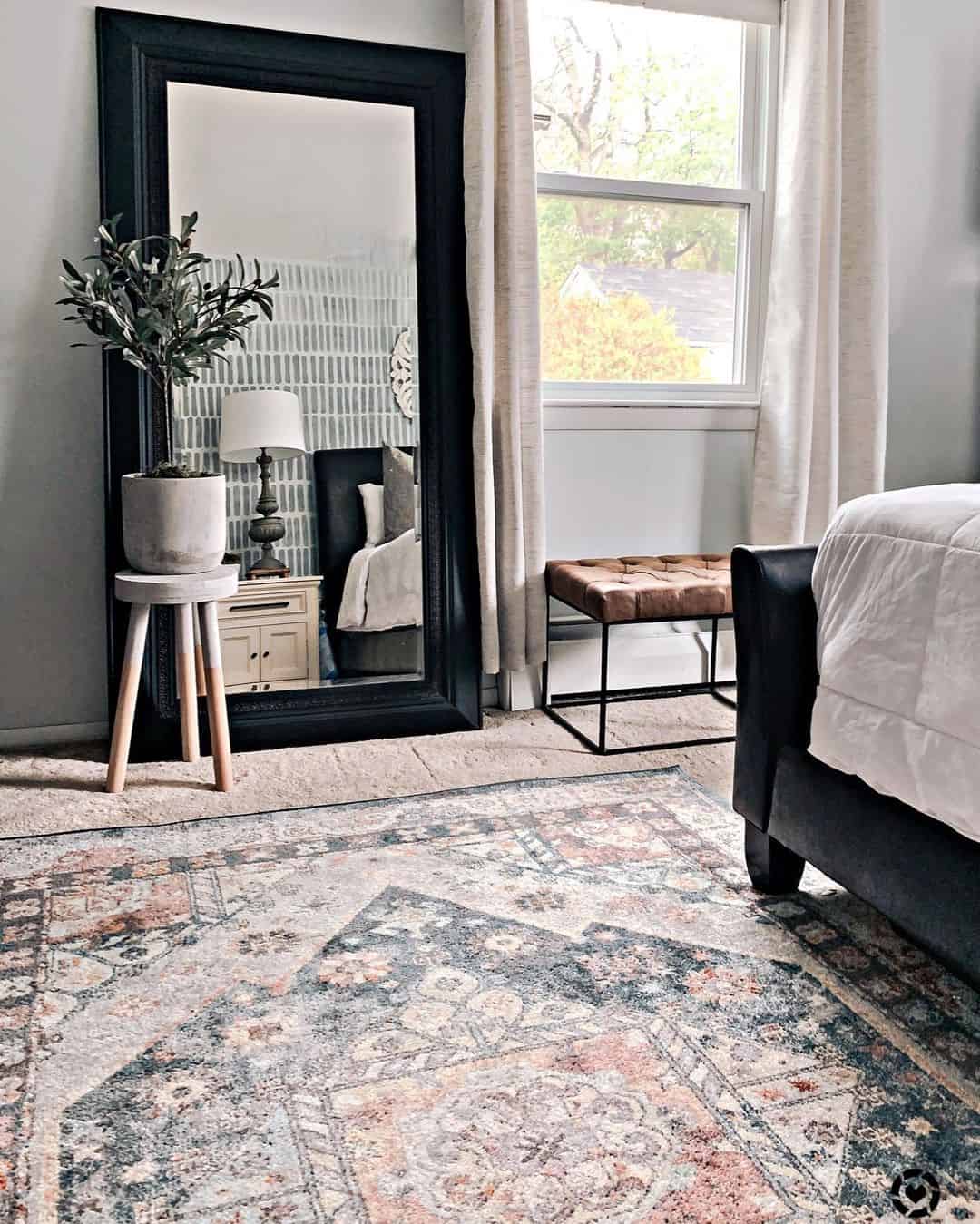 Oversized Black Floor Mirror Frames a Bedside Vignette