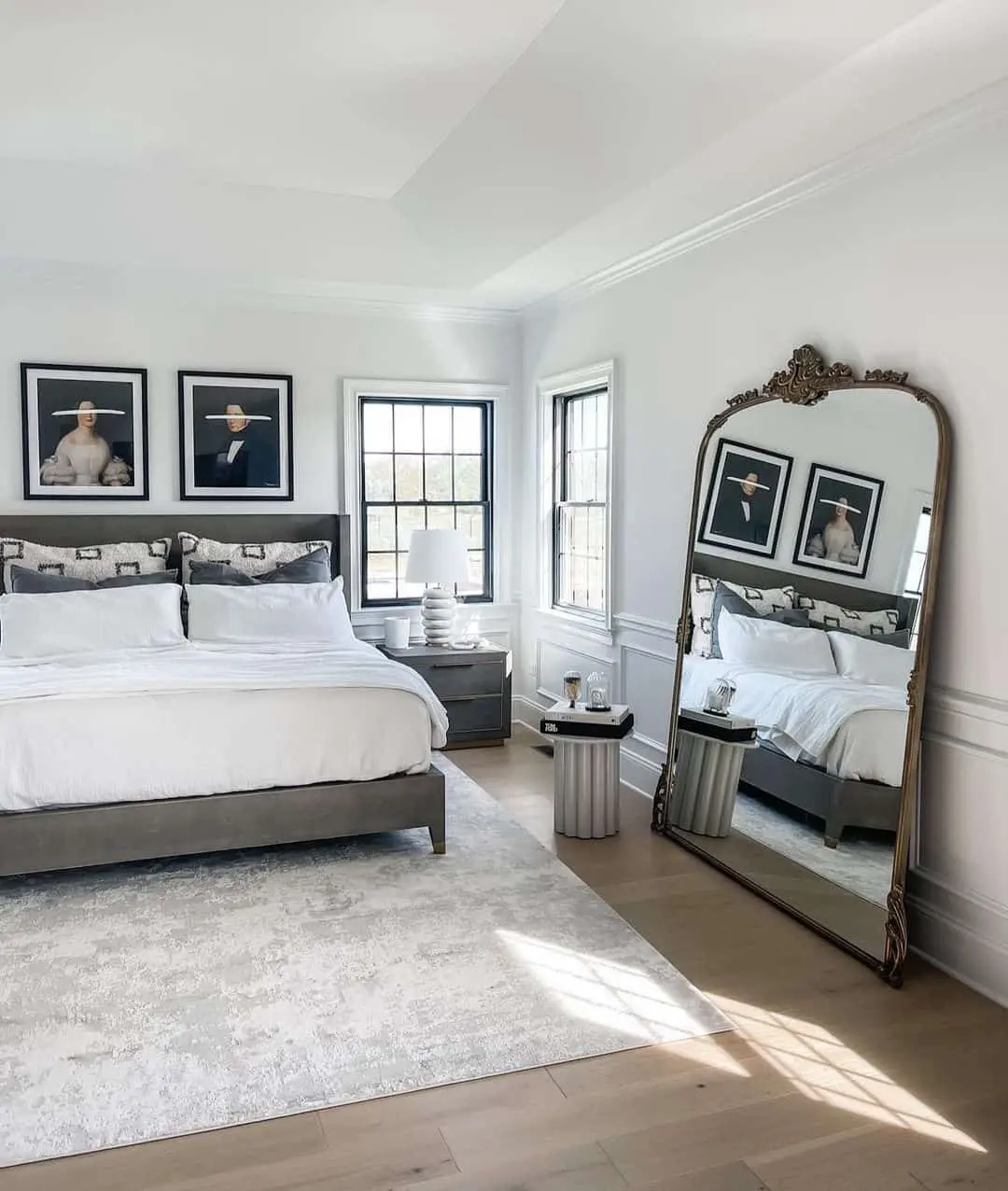 Ornate Gold Mirror Reflects Bedroom's Artistic Portraits