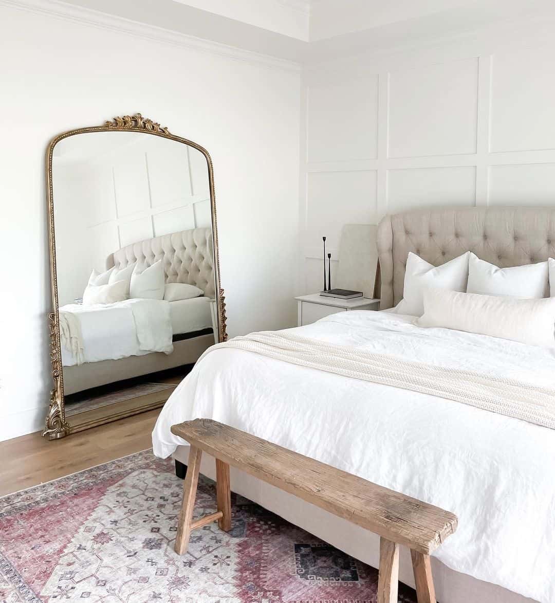 Ornate Gold Mirror Frames a Serene Bedroom Scene