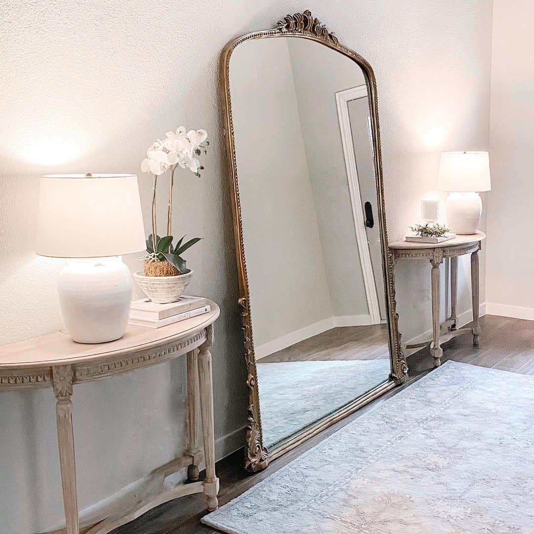 Ornate Gold Mirror Anchors a Pair of Console Tables