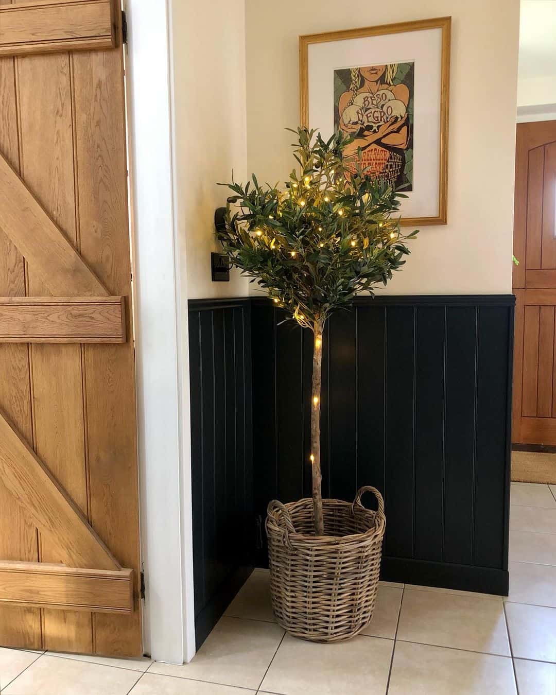 Black Wainscoting Anchors a Twinkling Olive Tree