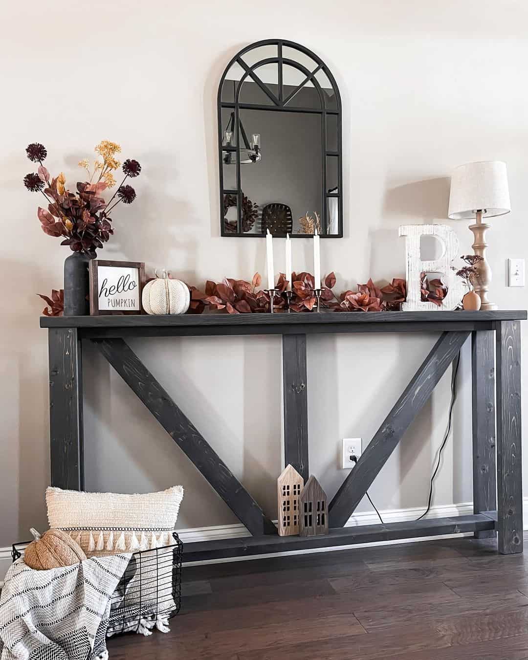 Arched Mirror Frames a Seasonal Vignette of Leaves and Candles