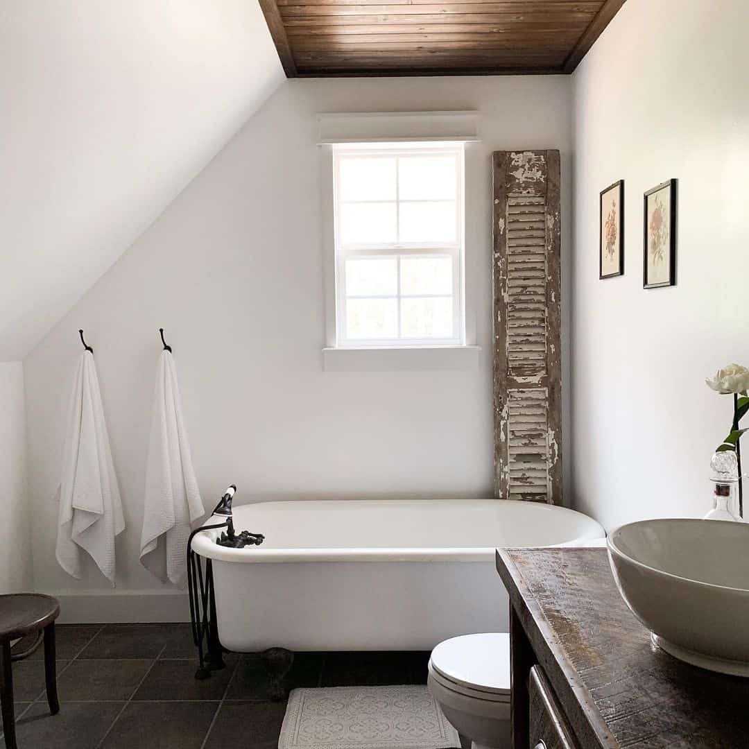 Distressed Wooden Shutter Adds Rustic Charm Beside the Tub