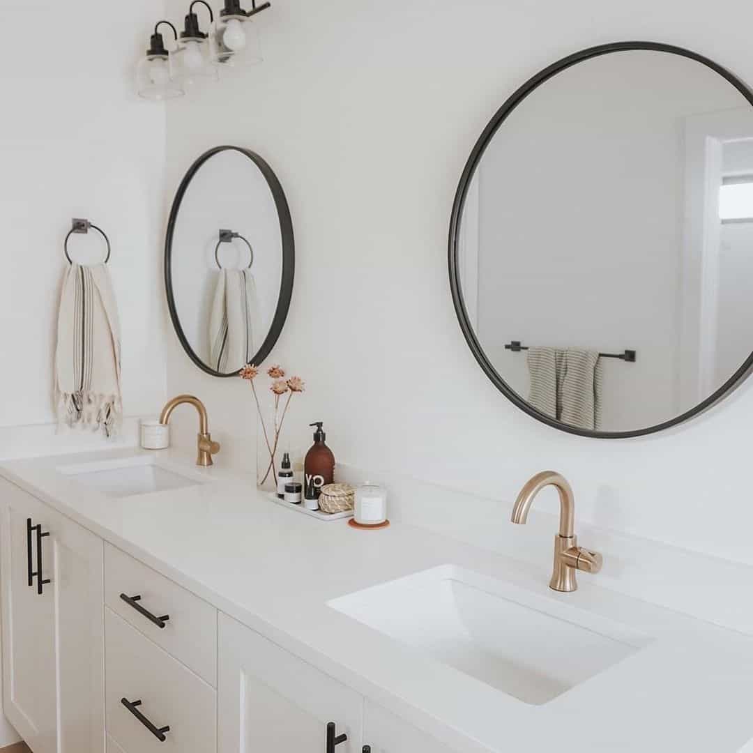 Round Mirrors With Slim Black Frames Frame the Vanity