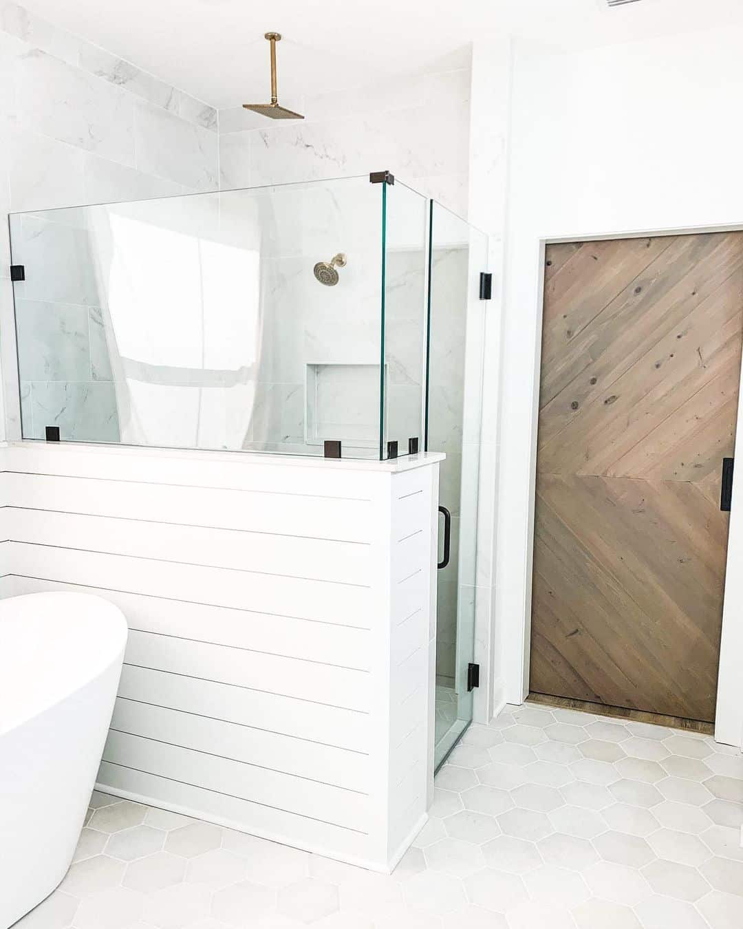 Shiplap Base Creates a Textured Visual Anchor for the Glass Shower
