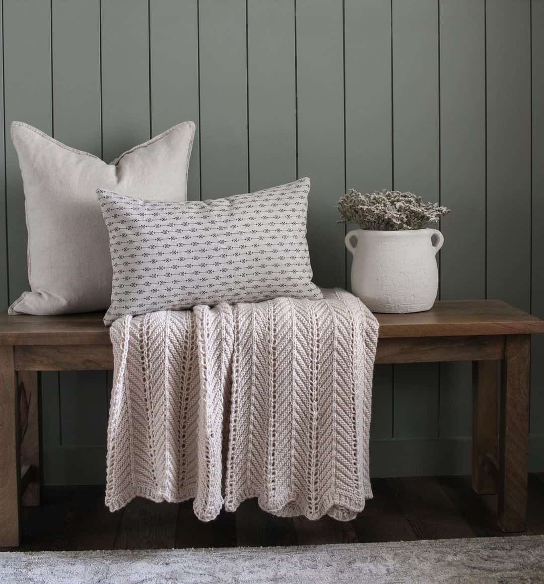 Paneled Green Walls with a Textured Throw and Pillows