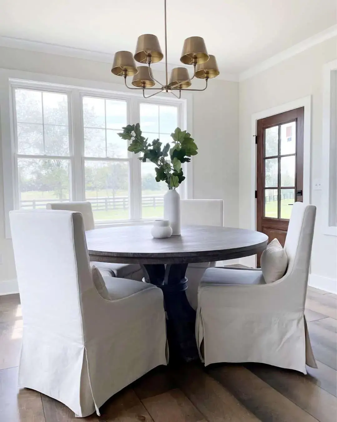 Tall White Vase Holds Lush Greenery for a Dramatic Statement