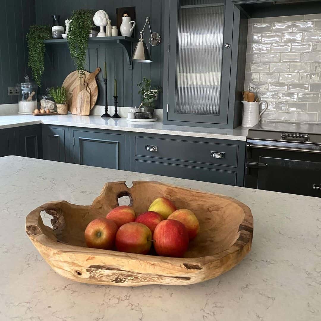 Carved Wood Bowl Anchors Fruit Display on Countertop