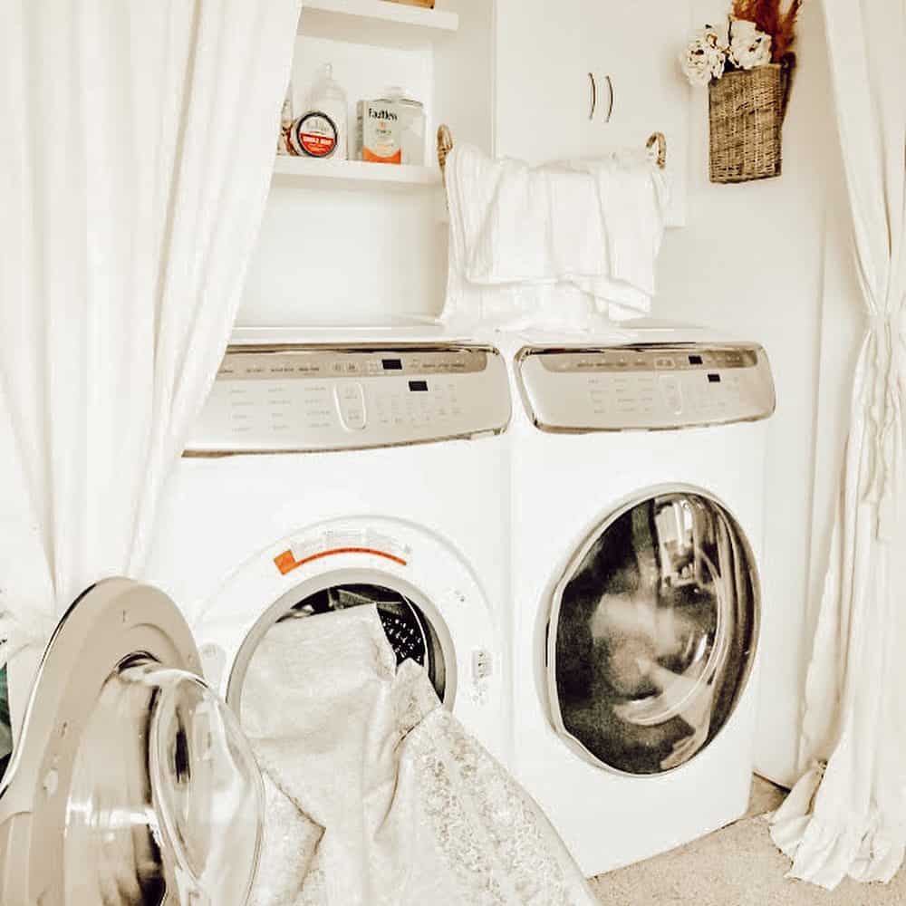 White Towels Hung on a Double Bar Near Shelving