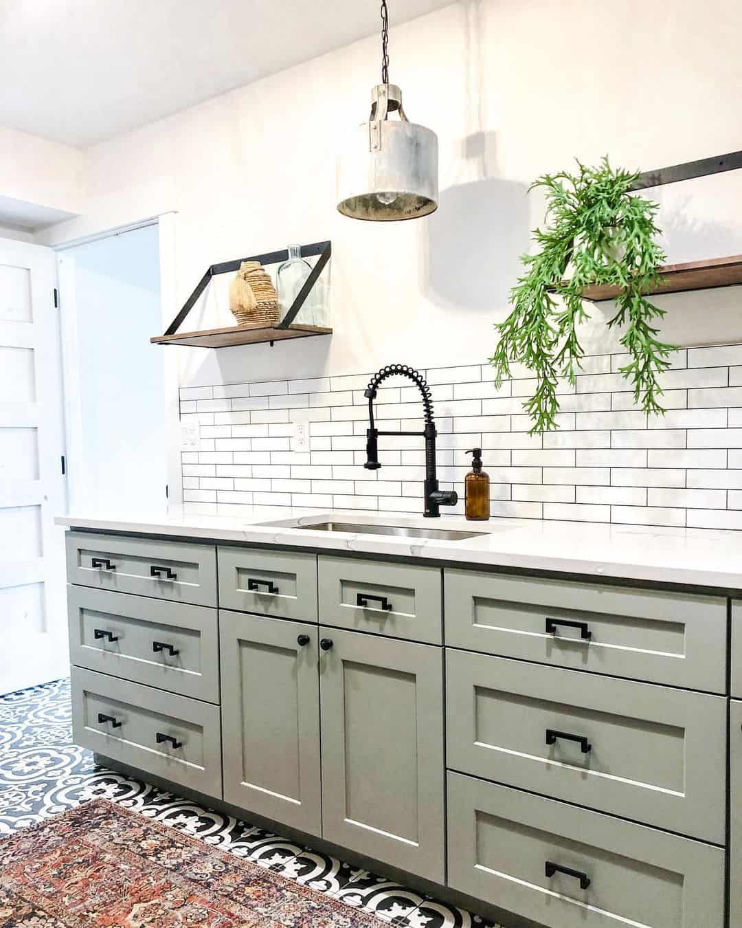 Ground your sage green cabinets with minimalist black hardware