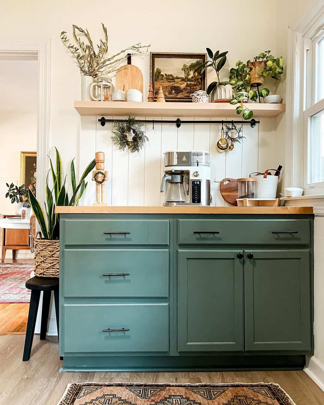 Combine sage green cabinets with a wooden countertop and black hardware