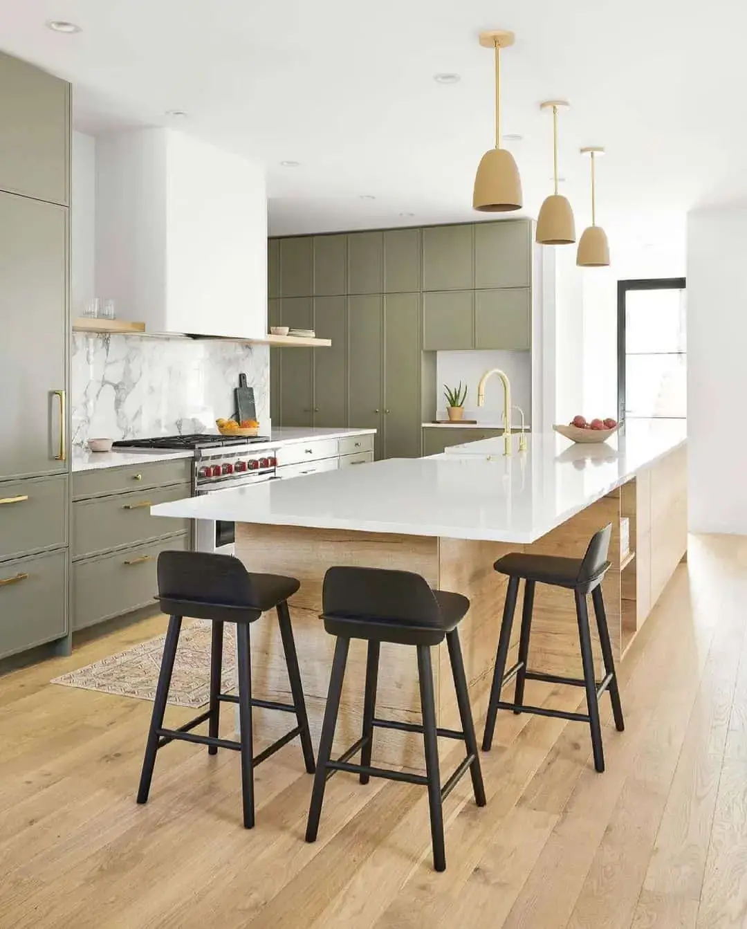 Sage green cabinets with a waterfall island countertop