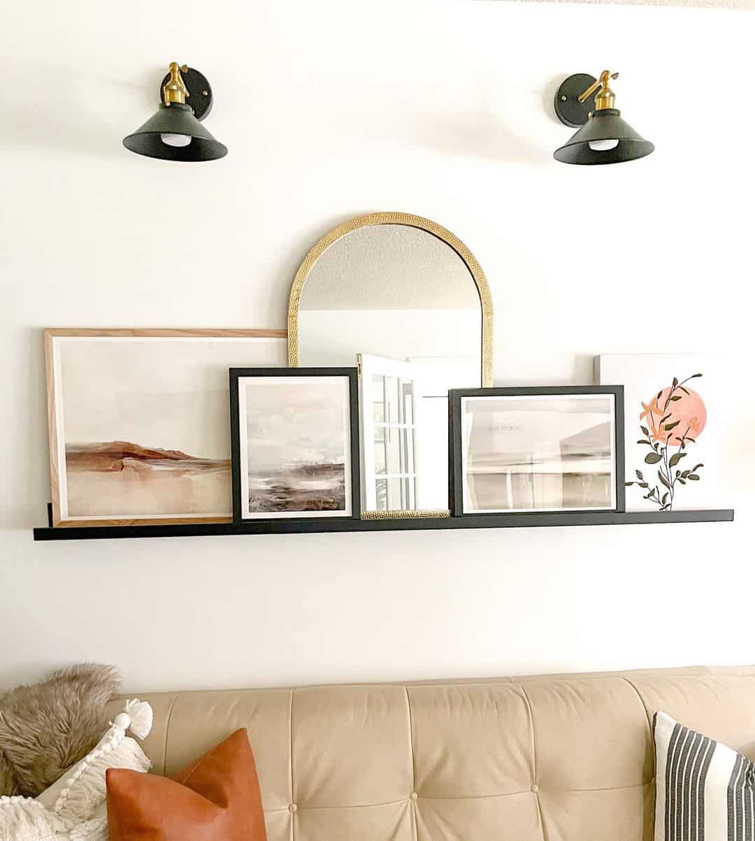 Gold Arched Mirror Adds Glamour to Art Display on Shelf