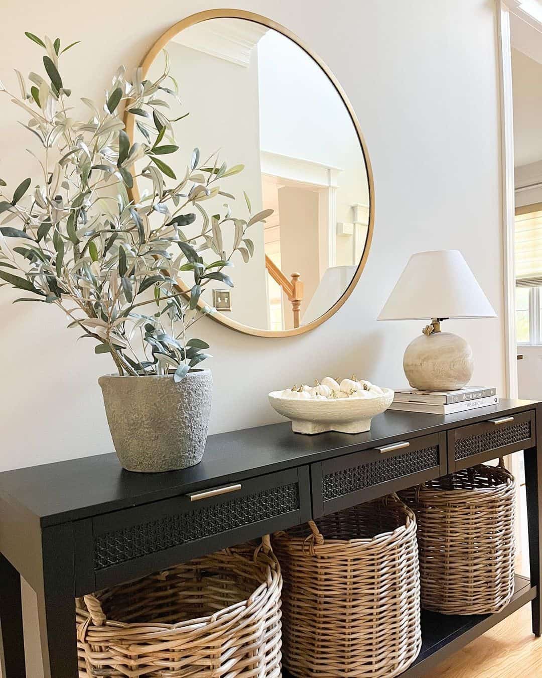 Round Gold Mirror Reflects Light Above Console