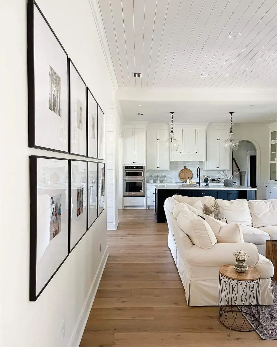Tall Gallery Wall of Black-Framed Photos Creates a Dramatic Statement