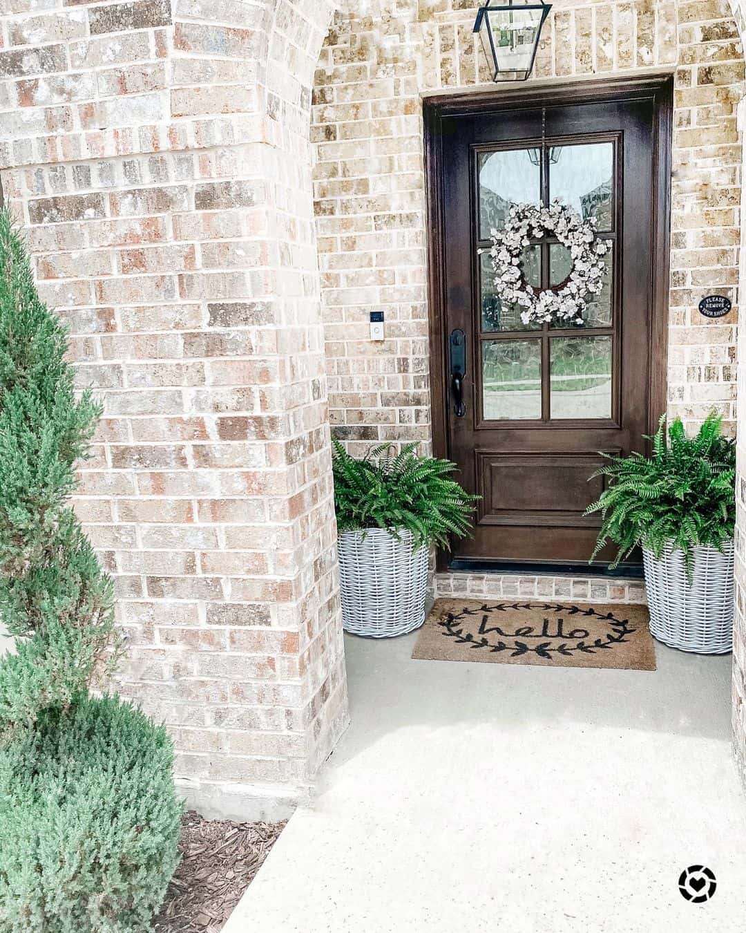 Woven Baskets Hold Lush Ferns Beside a Dark Wood Door