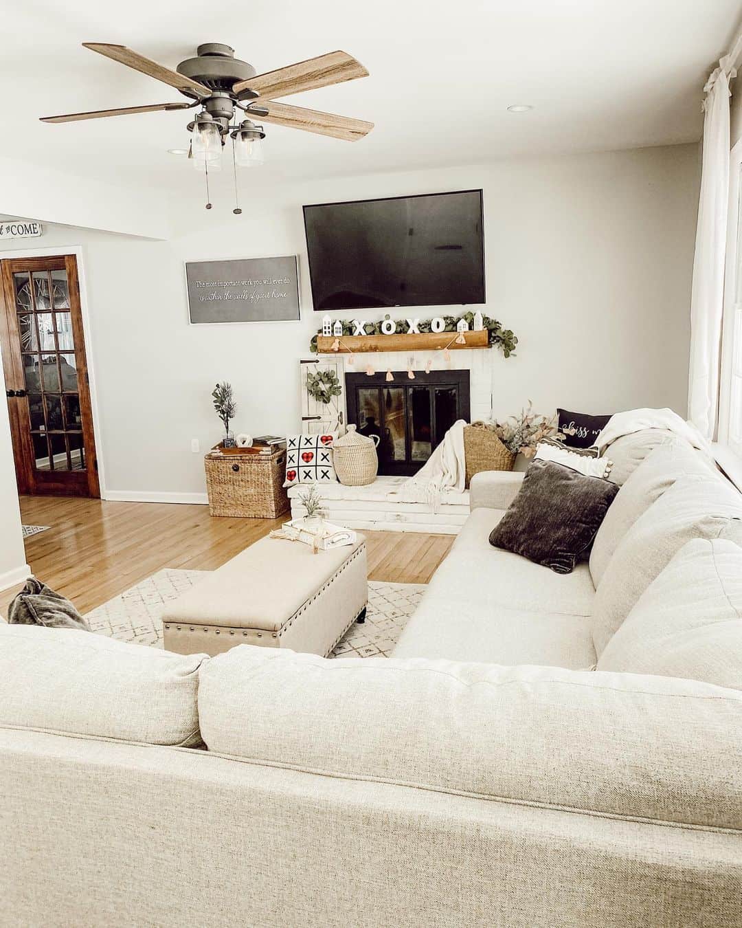 White brick fireplace surround with a rustic wood mantel