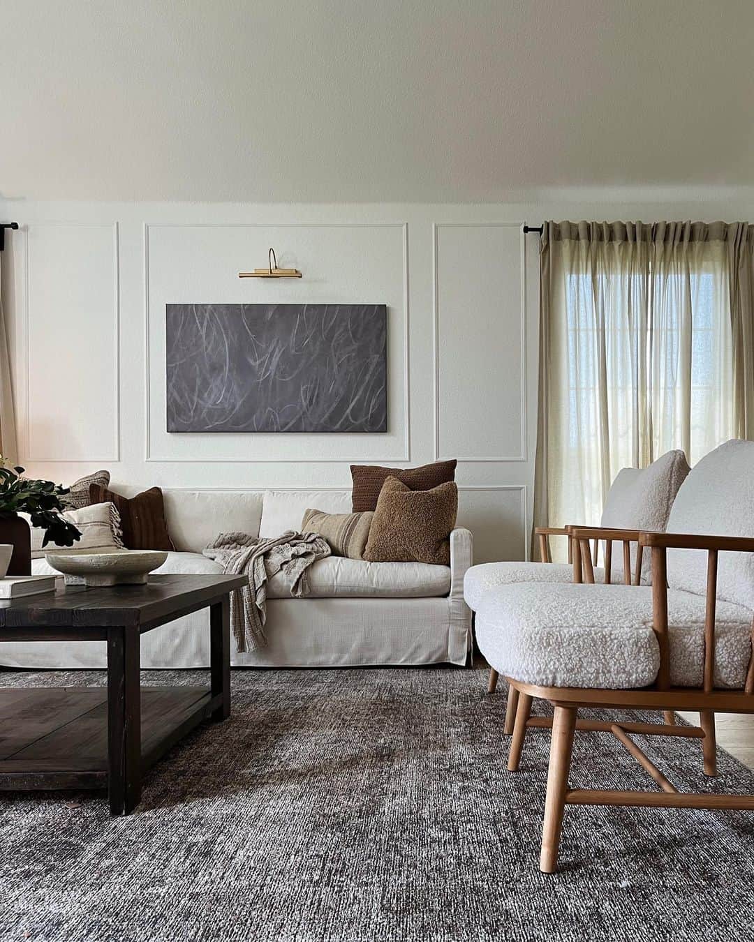 Framed abstract art adds a moody focal point above a sofa