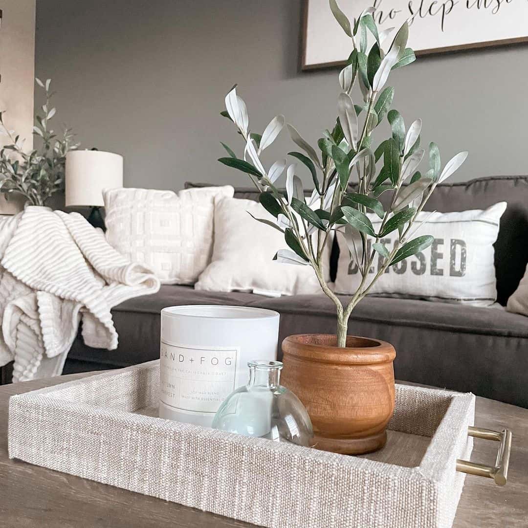 Fabric-covered tray with metallic handles organizes coffee table vignettes