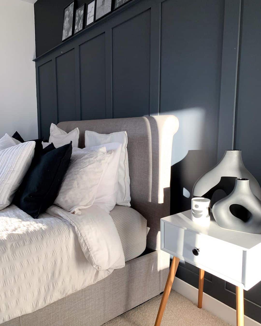 Dark Vertical Panels Frame a Bedroom with Black and White Accents