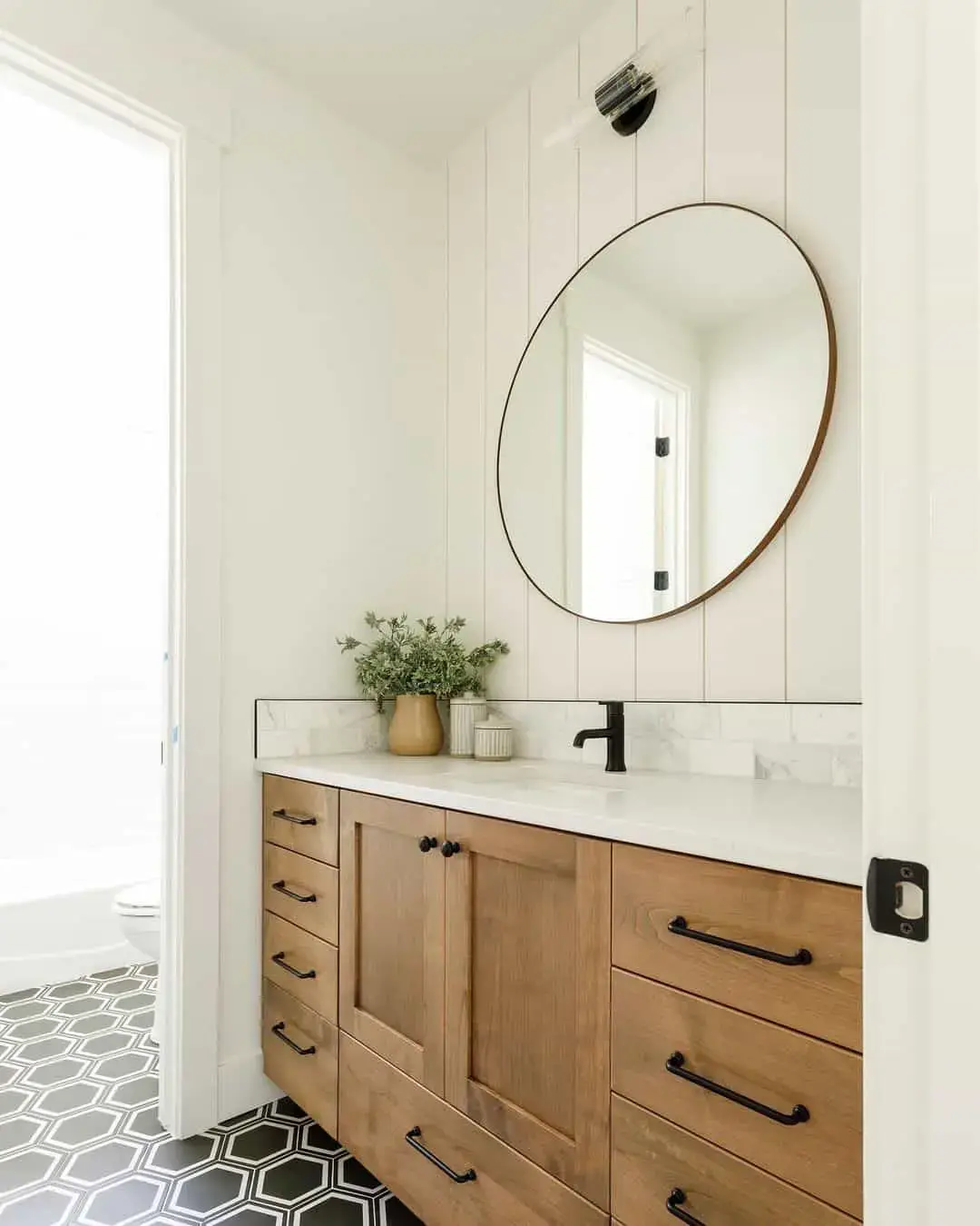Minimalist Round Mirror Above a Natural Wood Vanity