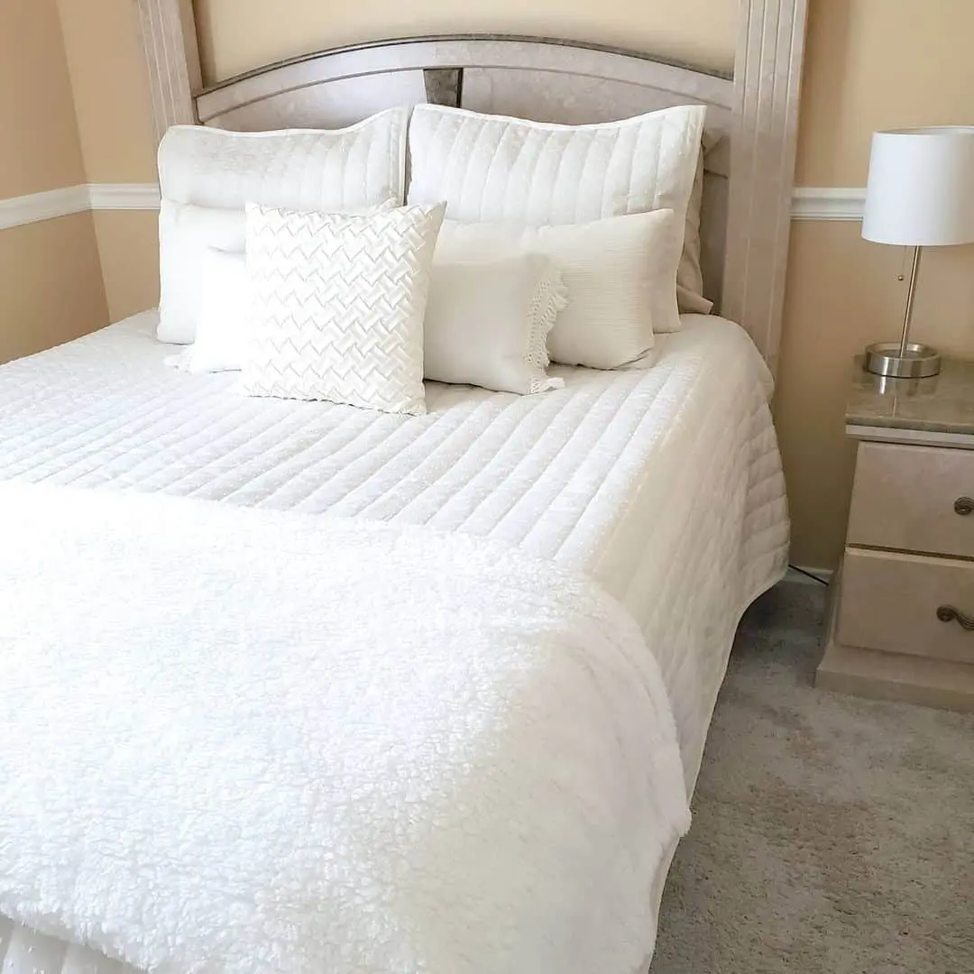 Layered White Pillows Add Tactile Interest to the Bed
