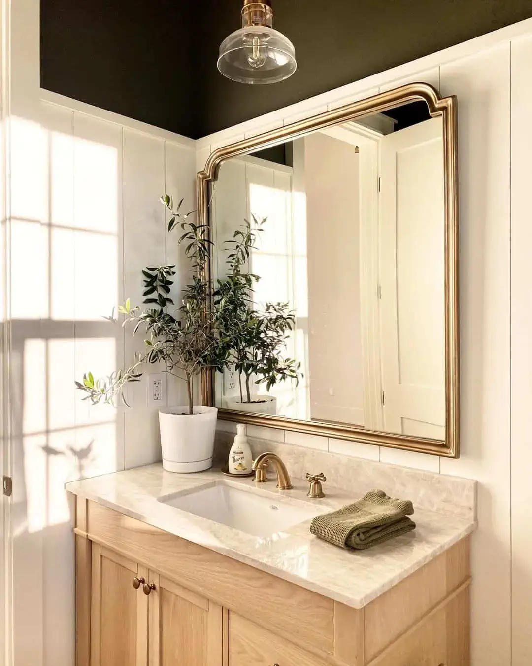 Ornate Gold Mirror Tops a Simple Warm Wood Vanity