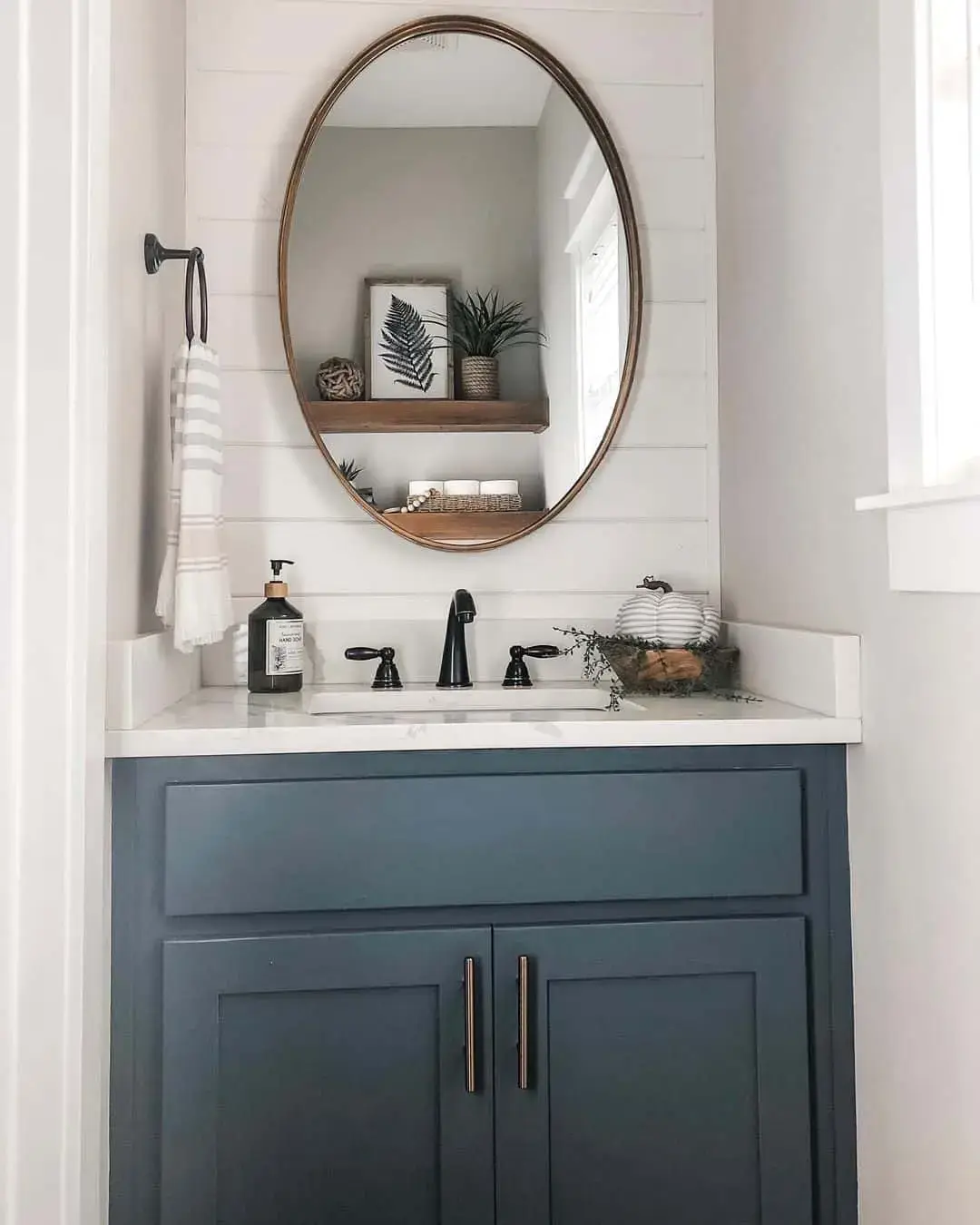 Slim Rose Gold Pulls Complement a Dark Teal Vanity