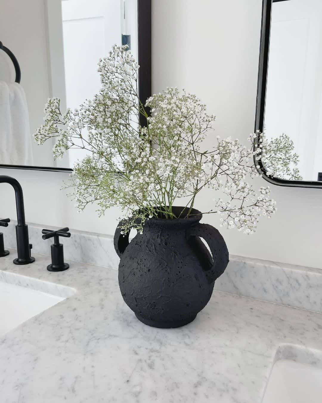 Textured Black Urn With Baby's Breath Adds Organic Shape to Marble Vanity