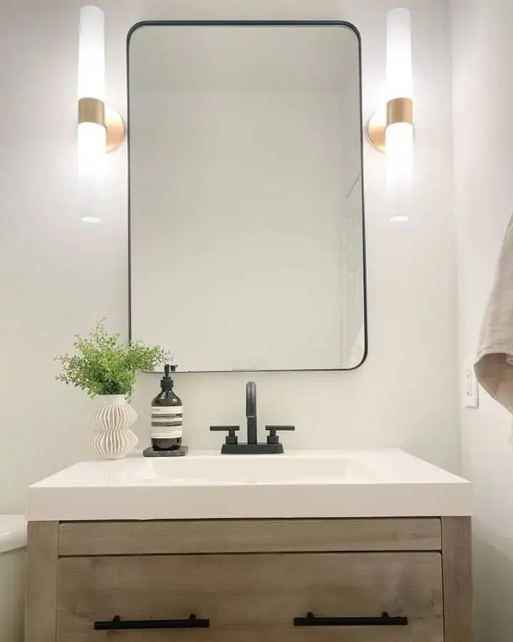 Frosted Sconces with Gold Bands Frame a Rounded Mirror