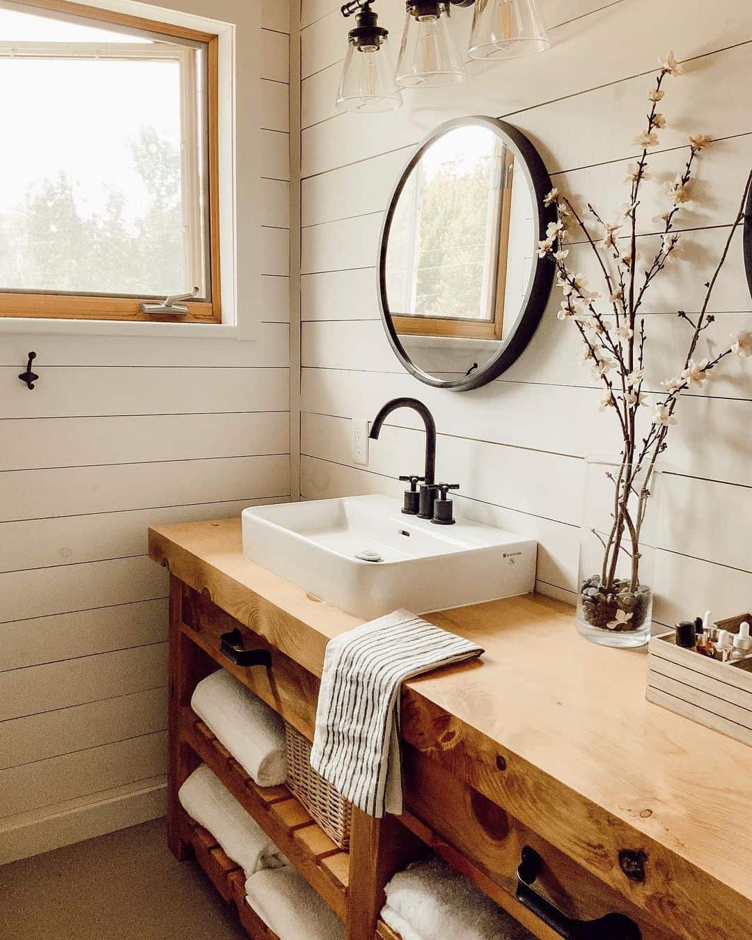 Round Black Mirror Frames a Simple Square Vessel Sink